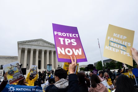 Demonstrators hold signs saying ‘Protect TPS Now’ and ‘Keep Families Safe Keep TPS’ in front of the supreme court building