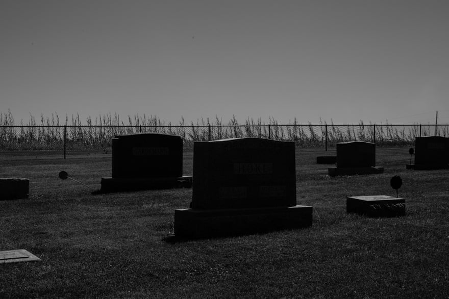 A dead corn field lies behind the fence of a local cemetery in Atkins, Iowa.