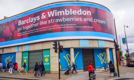 The exterior of a building in Wimbledon town centre displays an advert with the slogan 'Barclays and Wimbledon go together like strawberries and cream’