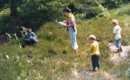 A family snapshot of a woman and three small children in grassland
