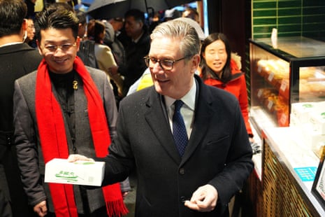 Keir Starmer holding a box of biscuits on a visit to Yuyuan Garden in Shanghai, China