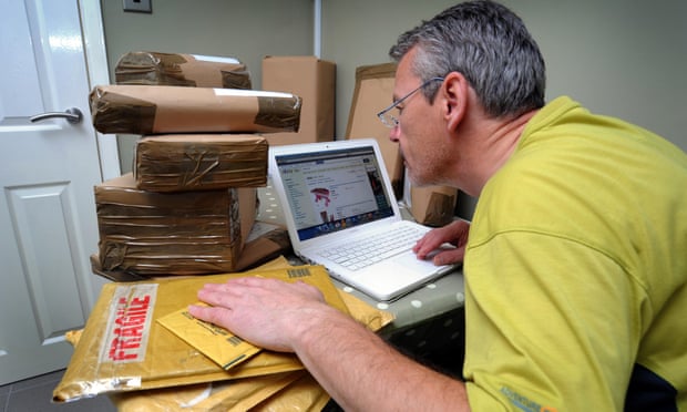 A seller trading on eBay with a pile of parcels.
