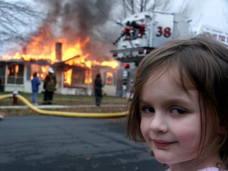 Photo of Zoe, a girl with an apparently evil smile, who came to be known as Disaster Girl, standing in front of a house on fire, taken by her father David