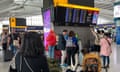 Passengers look at the departures board at Heathrow airport in London