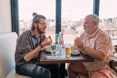 Two men facing each other across a restaurant table