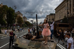 A girl stands on top of destroyed Russian military equipment at Khreshchatyk street, that has been turned into an open-air military museum ahead of Ukraine’s Independence Day on August 24
