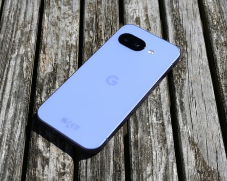 Google Pixel 9a laying screen down on a wooden table showing its coloured back.