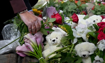 A woman lays flowers in front of the Fields shopping mall.
