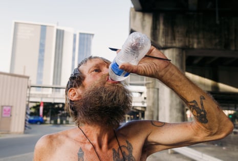 Daniel Watson chugs some water provided to him by Lettie Vaughn.