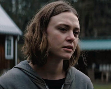 A closeup shot of Hayley Erin, with buildings behind her in the background