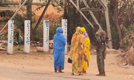 An army soldier talks to women on a street in Khartoum on 6 June, as fighting continues in war-torn Sudan.