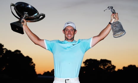 Rory McIlroy holds aloft the FedEx Cup and Tour Championship trophies after his stunning play-off victory over Ryan Moore on Sunday.