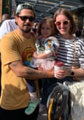 Lizzie Manchester in round sunglasses and her partner Dnieper Cruz hold their daughter Lumi, age three, at King’s Cross station
