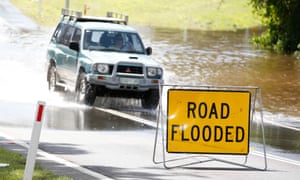 A vehicle passes through a flooded street. An Asic review found few listed companies outside of the ASX 200 were disclosing climate risks to their investors.
