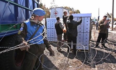 Syrian officials inspect boxes of apples from the Red Cross at the Syrian-Israeli border.