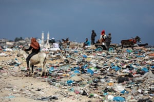 Pessoas coletam plástico de um depósito de lixo em Beit Lahia, no norte da Faixa de Gaza