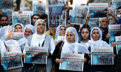 Protesters hold up copies of the Turkish daily Özgür Gündem