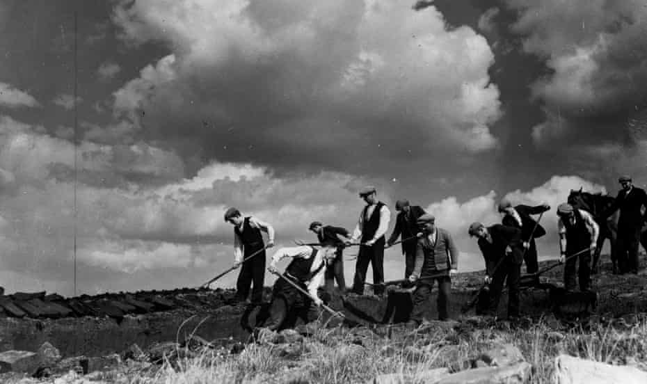 Nine farmers help a 10th to cut his turf from a bog in Ireland, circa 1940