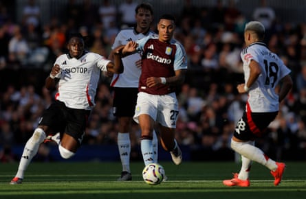 Morgan Rogers of Aston Villa dribbles between Fulham players Calvin Bassey and Andreas Pereira at Craven Cottage on 19 October 2024