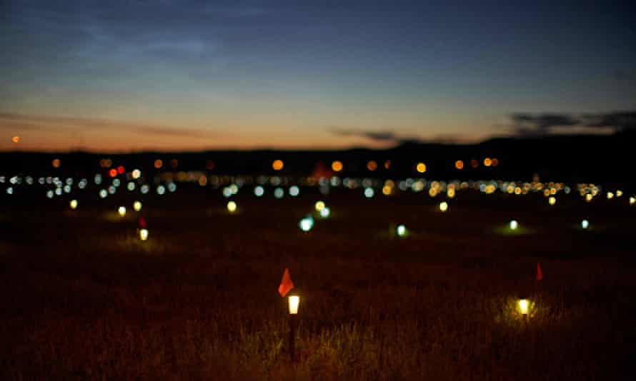 Lights and flags mark indigenous graves