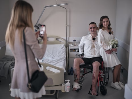 Mykhailo (25) and Vladislava (19) pose in the hospital ward during their wedding day on Friday in Lviv, Ukraine. Mykhailo, an aerial reconnaissance officer, was seriously injured after hitting a mine. He lost one eye, and his leg was seriously damaged.