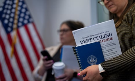 A staffer with the Republican leadership holds a guide to Speaker Kevin McCarthy's debt ceiling package during a news conference at the Capitol