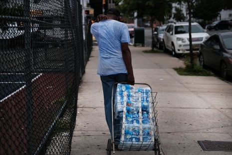  People wait in line for bottled water at a recreation center in Newark, New Jersey. 