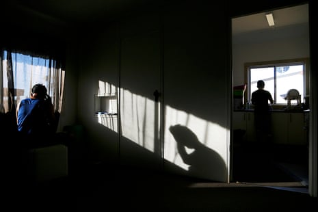 Asylum seeker Zaman chooses a quiet corner in his crowded share house to speak to his wife and daughter in Afghanistan