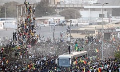 TOPSHOT-FBL-AFR-AFCON-2021-2022-SEN<br>TOPSHOT - Supporters cheer as a member of the Senegalese Football team raises the trophy in Dakar on February 7, 2022,  after winning, for the first time, the Africa Cup of Nations. - Senegal's President Macky Sall declared February 7, 2022, a public holiday to celebrate the national football team's first ever African Cup of Nations crown following their victory against Egypt. (Photo by JOHN WESSELS / AFP) (Photo by JOHN WESSELS/AFP via Getty Images)