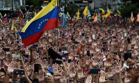 Guaidó supporters raise their hands at a rally in Caracas