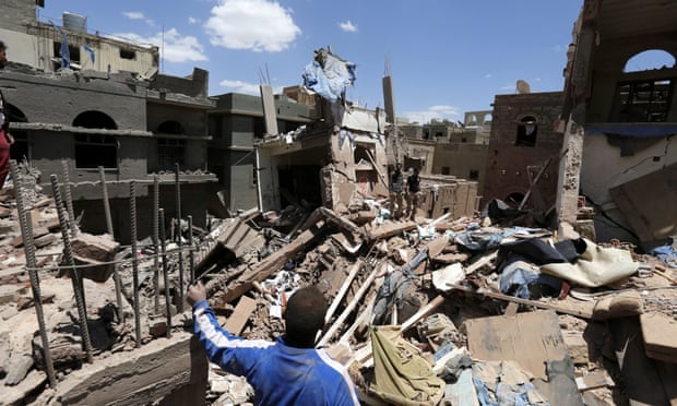 Yemenis stand over houses in Sana’a hit by an airstrike carried out by the Saudi-led coalition.
