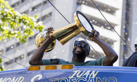 Draymond Green of the Golden State Warriors holds the Larry O’Brien trophy during the team’s championship parade through San Francisco in June.