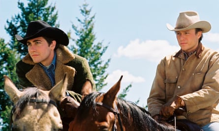 Jake Gyllenhaal and Heath Ledger on horses, both wearing cowboy hats