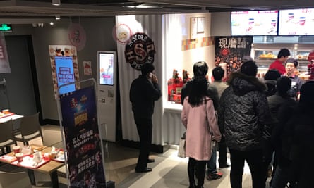 The facial recognition machine to the left sits unused as customers queue to be served by humans instead