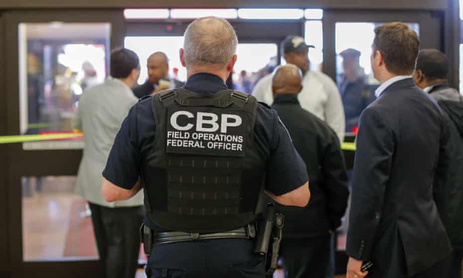 A Customs and Border Protection federal officer watches from inside the terminal during a protest at Hartsfield-Jackson Atlanta international airport, where Mohammed Tawfeeq was detained.