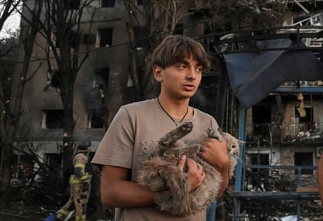 A resident holds his cat as he stands near his apartment building hit during a Russian drone and missile strike, in Zaporizhzhia, on Saturday.