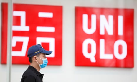 A security guard wearing a mask stands outside the first Uniqlo store in Hanoi