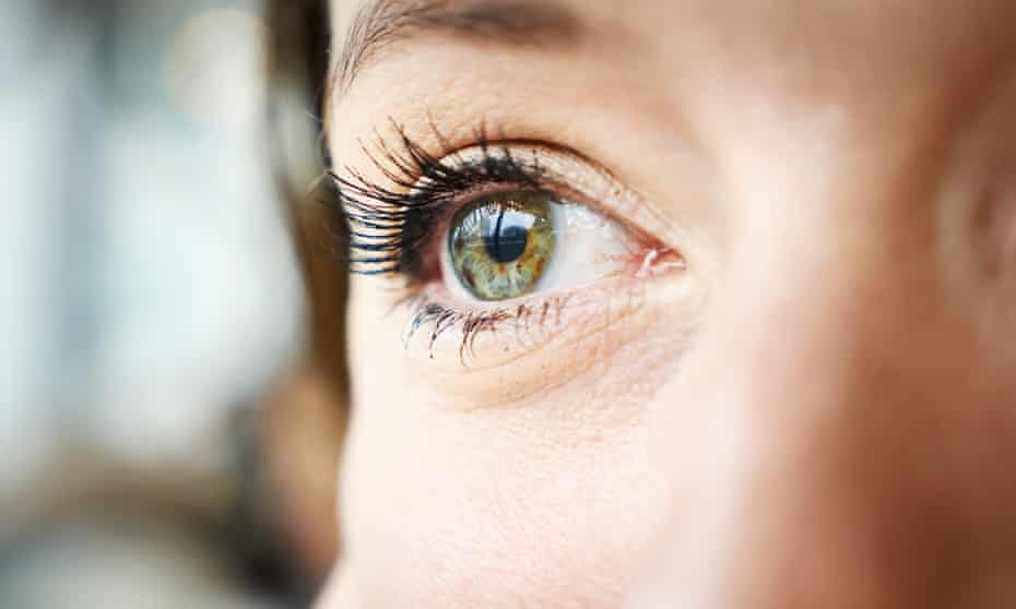 Cropped image of a woman's bright green eye
