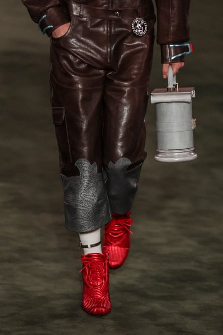 A model carries a cylindrical bag