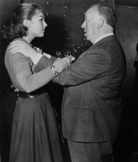 The director holds the actor’s shoulders as the pair stand face-to-face engaged in conversation.