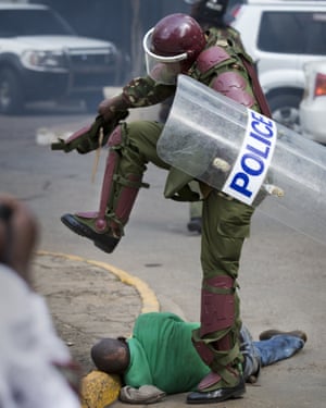 A Kenyan riot policeman repeatedly kicks a protester