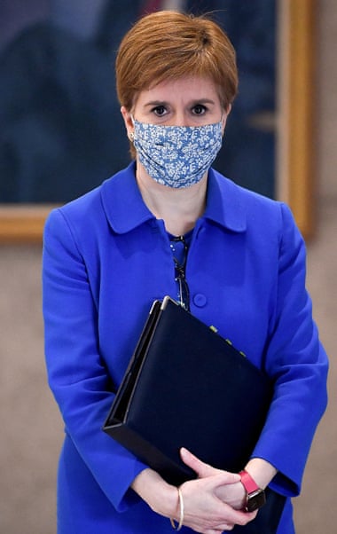 Nicola Sturgeon in a face mask holding a document folder