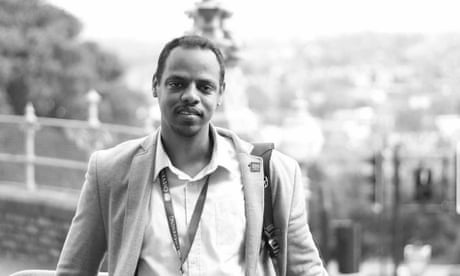 A black and white photograph of Alwaleed Abdeen looking happy taken after his graduation