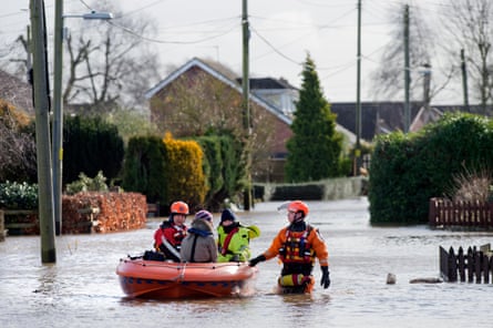 A flood rescue service carries a person in a boat
