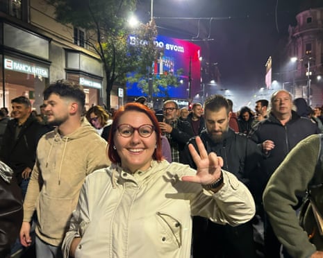 Ivana smiles and holds up three fingers among celebrating crowds in Belgrade at night