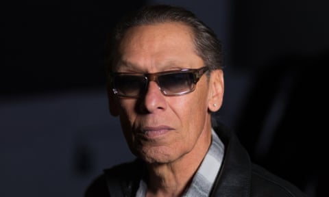 A man wearing sunglasses looks ahead
