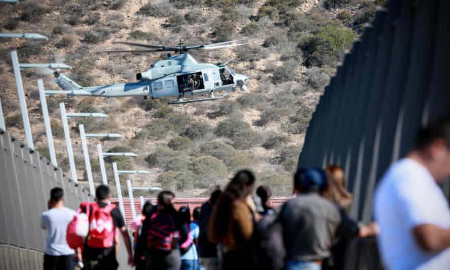 A US military helicopter flies past a pedestrian bridge after the closing of the United States-Mexico border south of San Diego, California.
