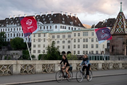 Cyclists ride past Euro 2025 flags.
