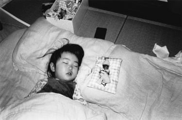 A child asleep in bed in black and white