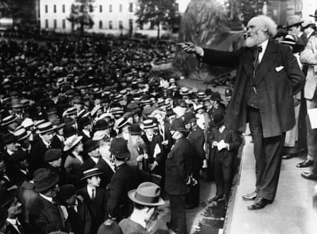 Wearing a suit and tie, Keir Hardie stands on a step addressing a crowd during a peace demonstration in Trafalgar Square, London